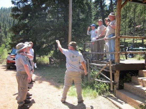 A group of people standing around in the woods.